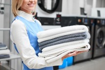 Portrait of a laundry worker on the background of clothes on hangers in dry cleaning Portrait of a laundry worker on the background of clothes on hangers in dry cleaning